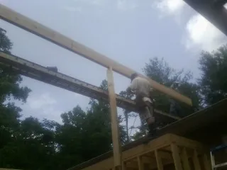 Carpenter setting a ridge beam over a new addition frame — Ice Dam Removal by Roofing Brothers in Buckingham